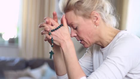 woman praying with rosary beads