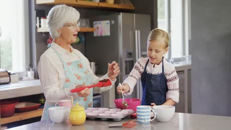 Happy-grandmother-and-granddaughter-filling-cup-cakes-4k