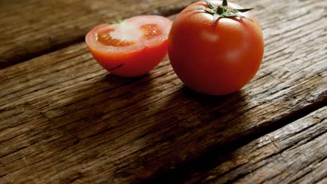 Full-and-half-tomatoes-arranged-on-wooden-floor-4K-4k