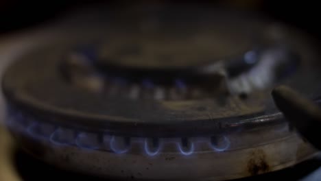 turning the flames on to heat the stainless steel pan for cooking - close up. 4k video