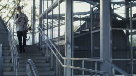 young man with bicycle on stairs in urban environment