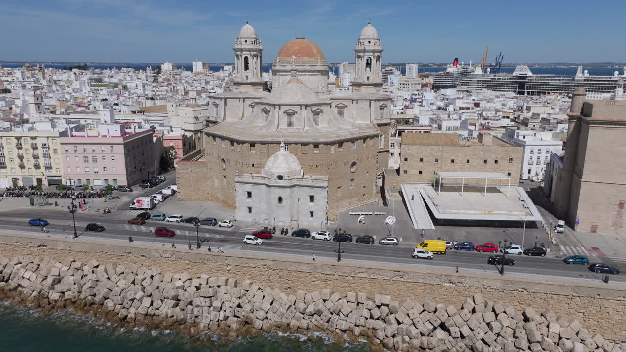 Vista aerea da drone del paesaggio urbano di Cadice, in Spagna, Andalusia, Europa, in una giornata di sole, con vista sulla Cattedrale di Cadice e sul lungomare. Drone che vola da sinistra a destra con panoramica