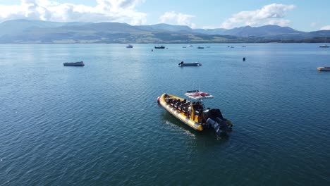 Snowdonia-clear-mountain-range-aerial-view-with-boats-anchored-on-sunny-calm-Welsh-shimmering-seascape