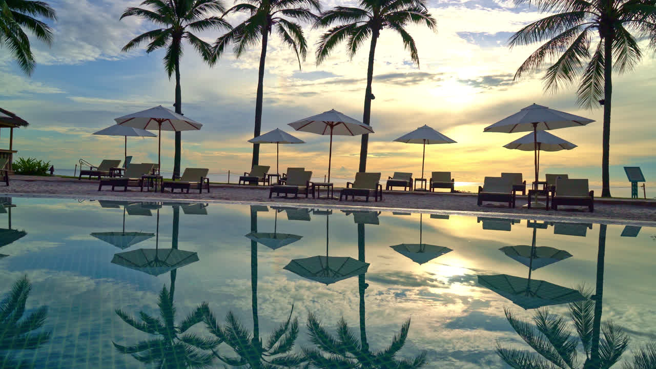 Paraply og stol omkring swimmingpool i resort hotel til fritidsrejser og ferie nær havet strand ved solnedgang eller solopgang tid