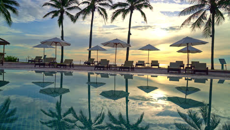 umbrella and chair around swimming pool in resort hotel for leisure travel and vacation neary sea ocean beach at sunset or sunrise time