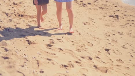 mother and daughter walking on the beach 4k