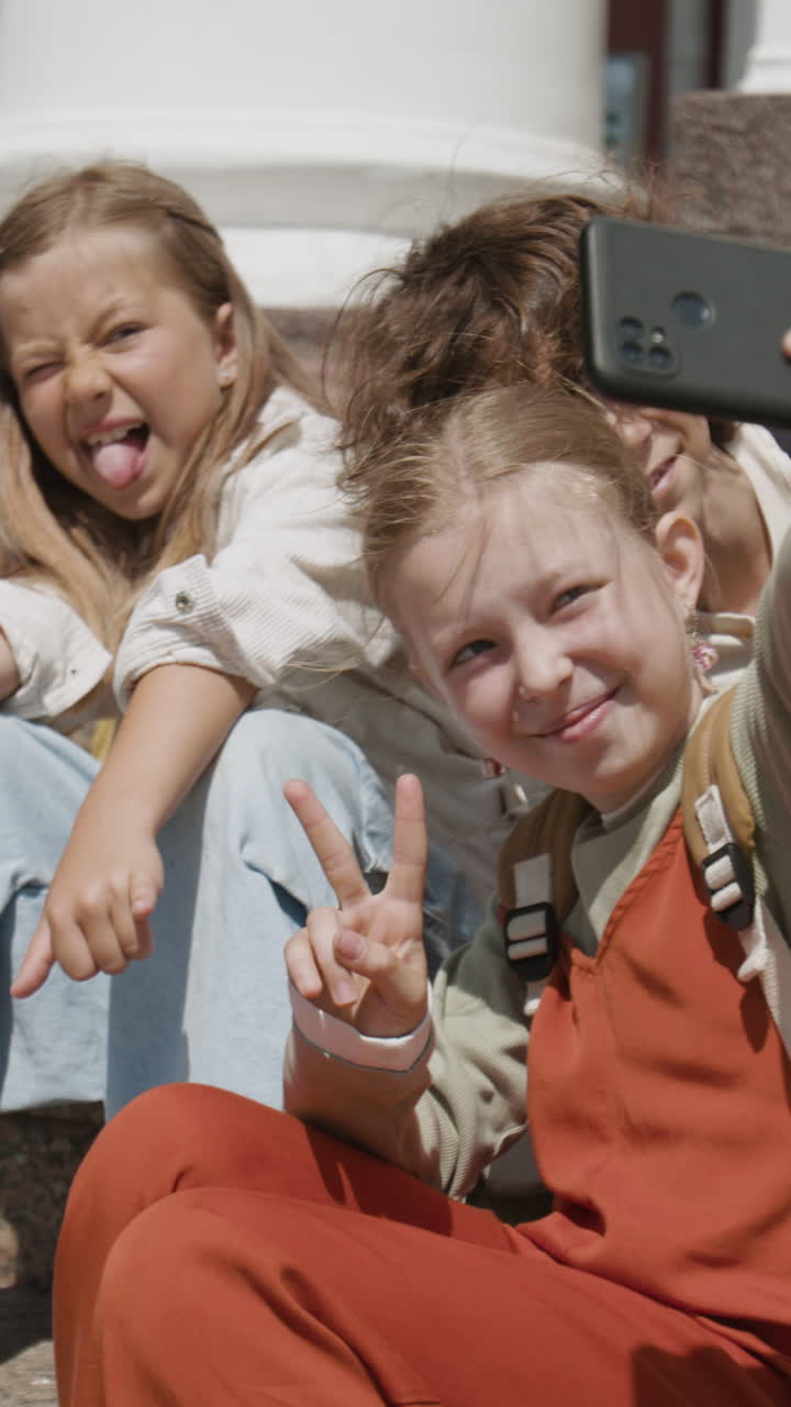 Happy Kids Taking Selfies and Interacting with a Smartphone Outdoors