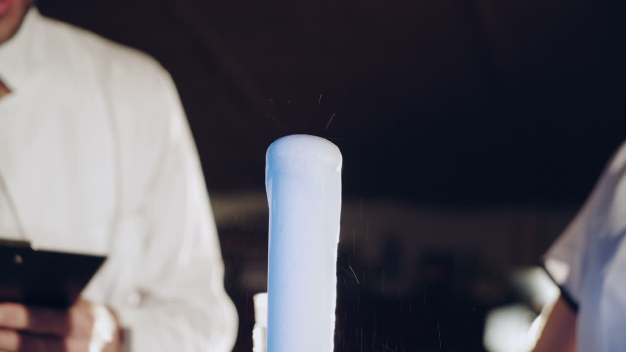 Woman scientist mixing together two liquid substances. Experiments in a chemistry lab. Close-up
