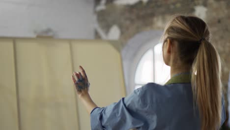 rare view of and artist measuring perspective in front her artwork in workshop