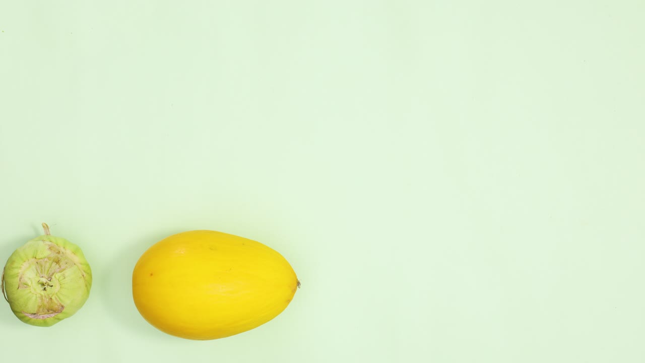 diferentes frutas y verduras frescas y maduras que pasan sobre un fondo verde claro.