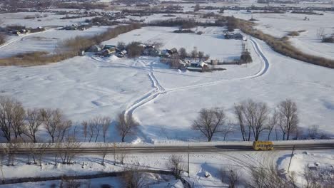 snowy rural village with a yellow bus