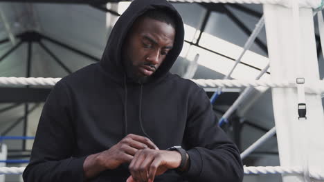 Male-Boxer-Training-In-Gym-Checking-Performance-Using-App-On-Smart-Watch-In-Boxing-Ring