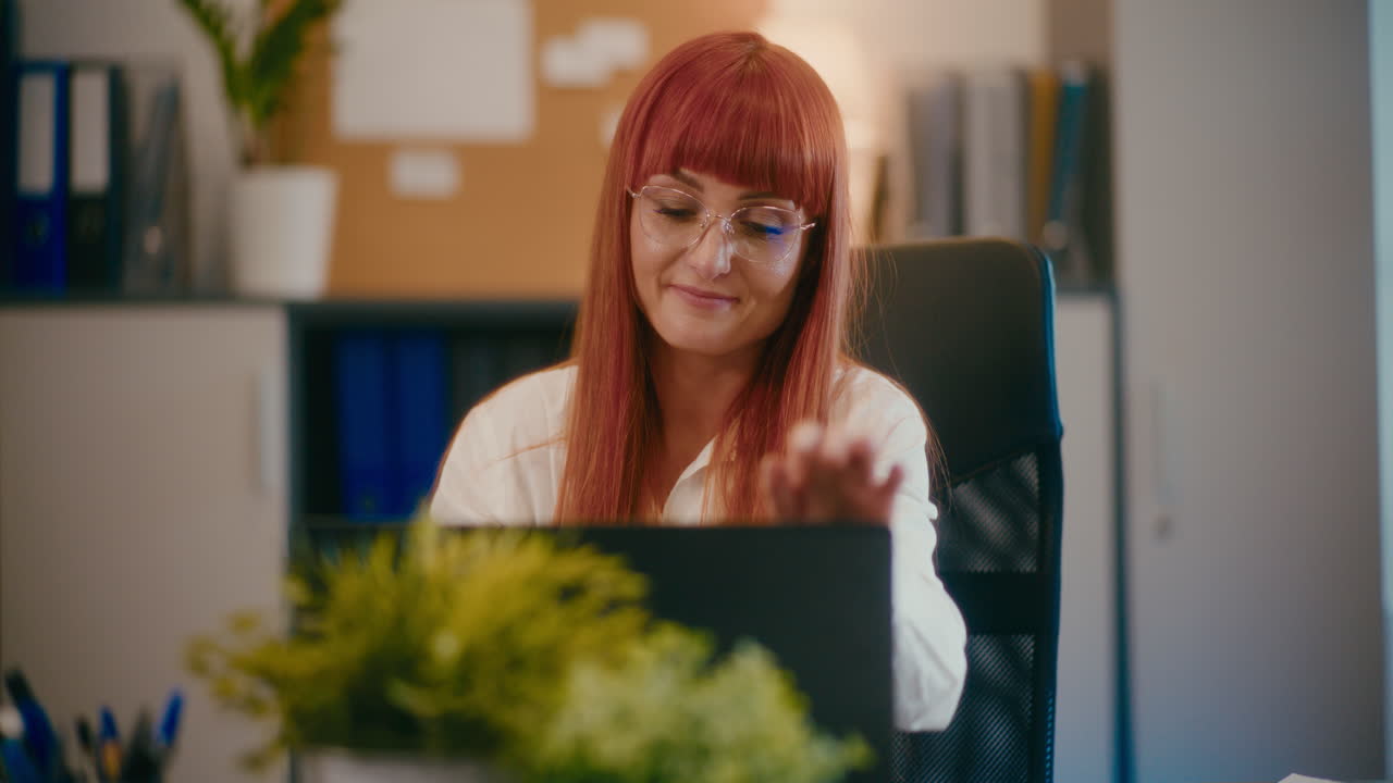 Ung manager med bærbar computer ved skrivebord på kontor