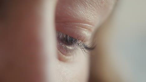 close-up of a mother's eye, filled with tenderness, as she watches her baby while breastfeeding