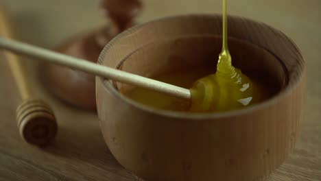 Thick-honey-dripping-from-the-spoon,-close-up.-Honey-flowing-honey-from-a-spoon