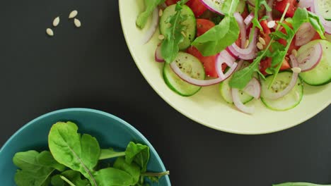 Vídeo-De-Ensalada-Fresca-Con-Hojas-Verdes-Y-Cuenco-Con-Hojas-De-Ensalada-Sobre-Fondo-Gris