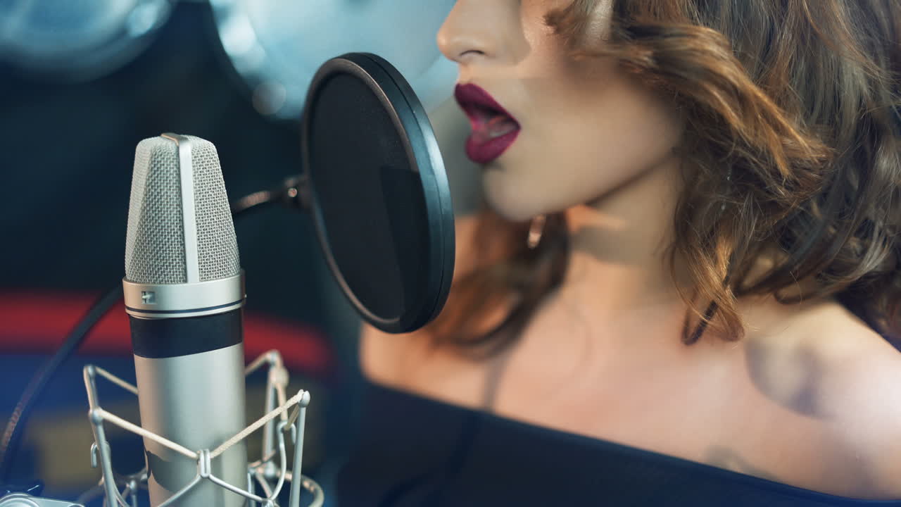 Woman singing in the recording studio. Profile of a woman with a beautiful face and lips.