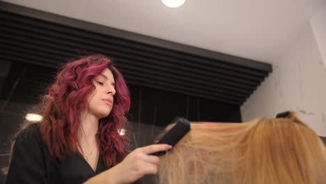 Hairdresser Dries Clients Hair in Salon and Dyes Highlights. Hairdresser dries clients hair in salon and dyes highlights. Woman with coloring foil on hair in salon