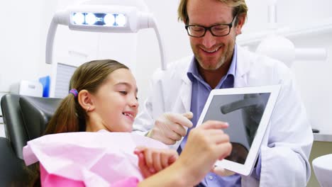 dentist showing digital tablet to young patient