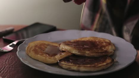 Verter-Y-Agregar-Más-Jarabe-De-Arce-En-Un-Plato-De-Panqueques---Primer-Plano