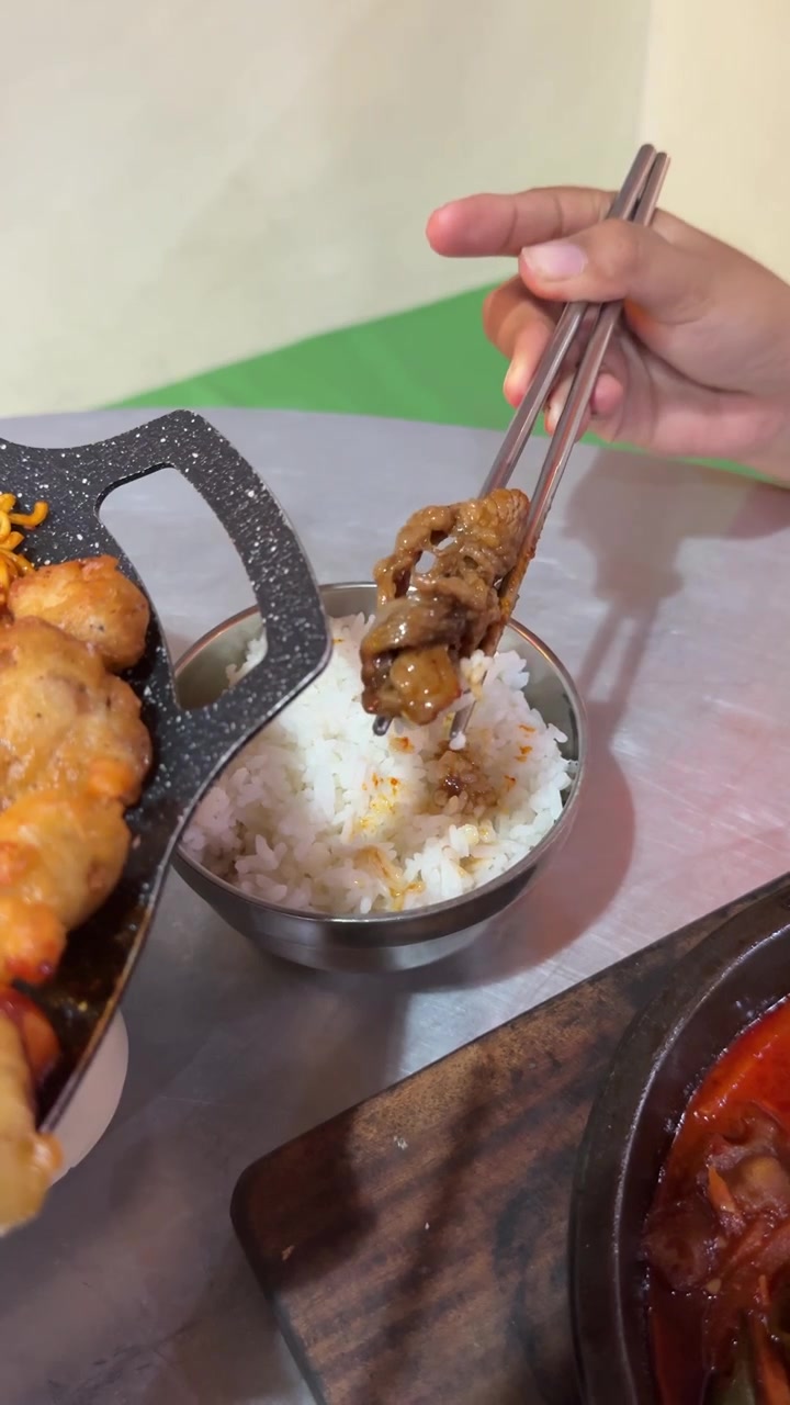 Seseorang Menggunakan Sumpit untuk Mengambil Daging Bakar