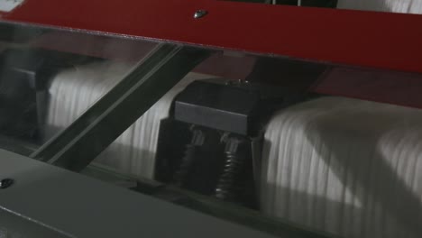 weaving mechanism is fabricating cloth from coloured threads