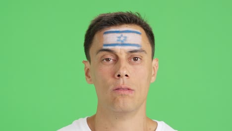 man with a israeli flag painted on the face smiling