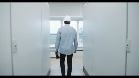 Engineer Walking Through Data Center Corridor