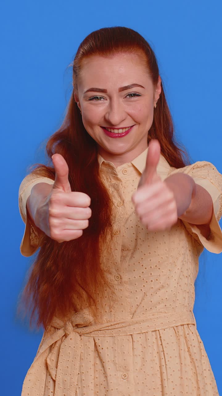 Young woman raises thumbs up agrees or gives positive reply recommends advertisement likes good idea