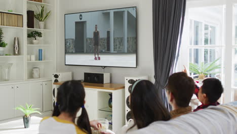 행복 한 가족 이 집 에서 함께 앉아서 tv 에서 육상 경기 를 보고 있다