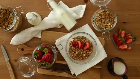 persona sin rostro decorando muesli con fresas frescas en la cocina