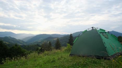 holidays in a campsite in the alps the couple rested holidays in a campsite in the alps the couple rested in a green tent and looked at the beautiful mountains rest in a tent