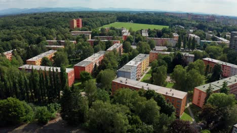 aerial drone shot of flat apartment complex with park, forest and beskydy mountains view