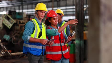 concepto de aprendiz de formación. ingeniero masculino caucásico explica el procedimiento para el uso de la máquina robot de metal correcta en la fábrica industrial de torno.
