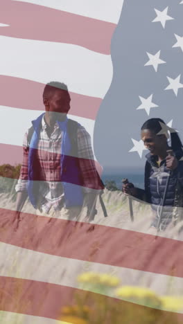 animation of american flag over smiling diverse couple hiking in mountains