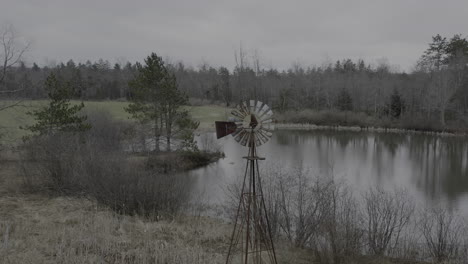 drone orbit shot of old still windmill pump