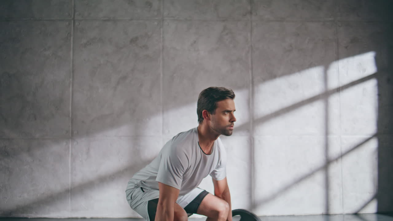 Uomo muscoloso che fa squat con il bilanciere in palestra. Uomo sportivo che allena le gambe