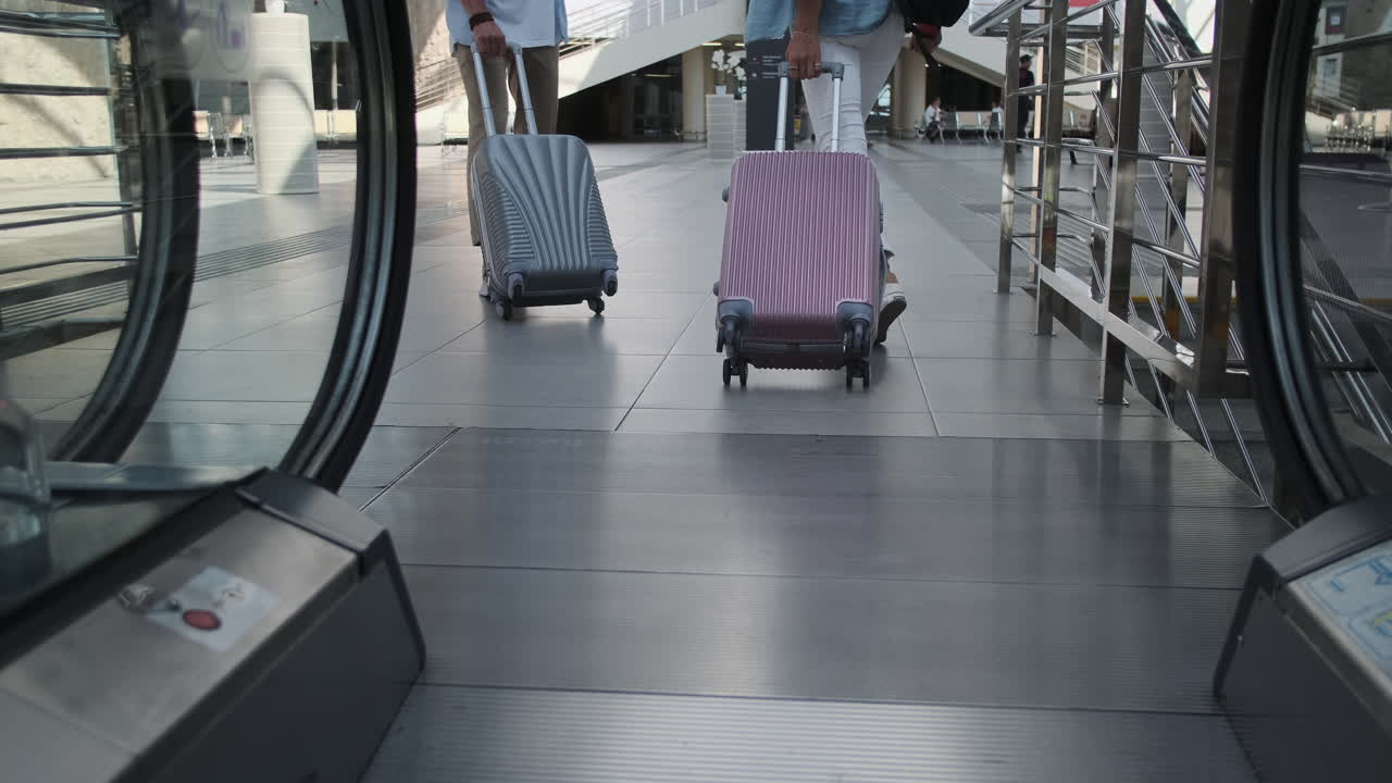 공항 에스컬레이터 를 타고 여행 하는 부부