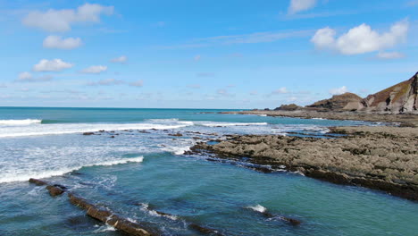 imagens costeiras de drones de ondas quebrando em rochas ao longo da costa de devon, no reino unido