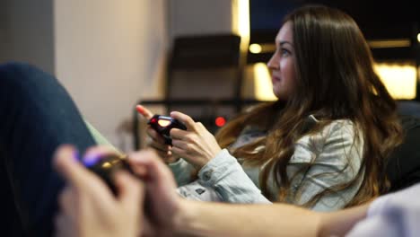 una pareja joven jugando un videojuego en casa. un hombre explicando cómo jugar y usar el controlador de juego. controlador de juego inalámbrico