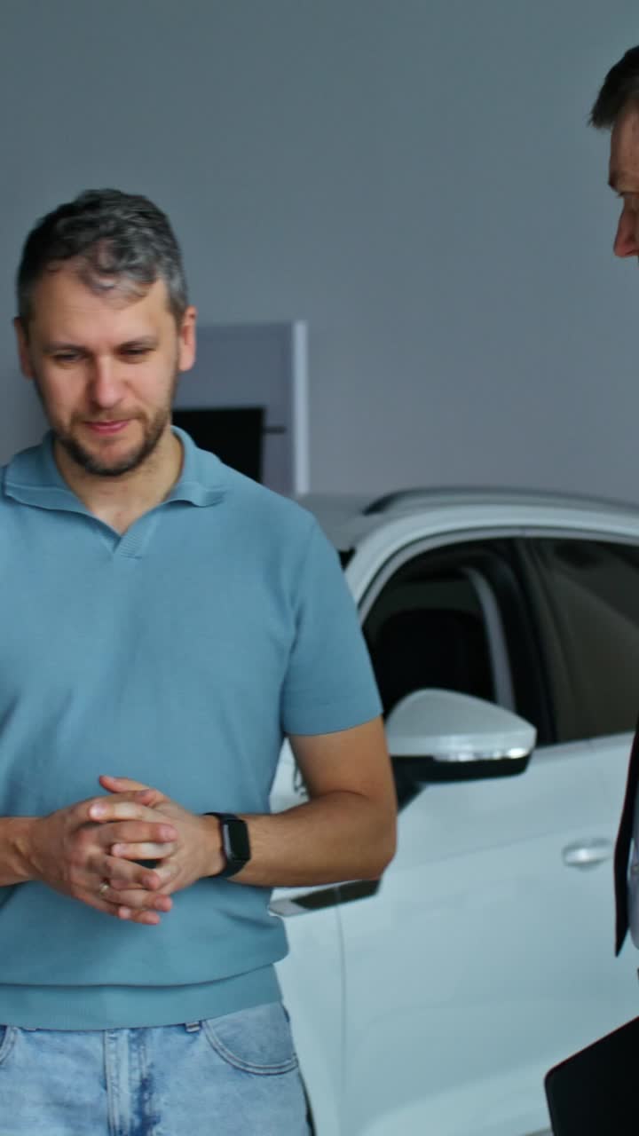 hombre discutiendo coche con un vendedor en el concesionario