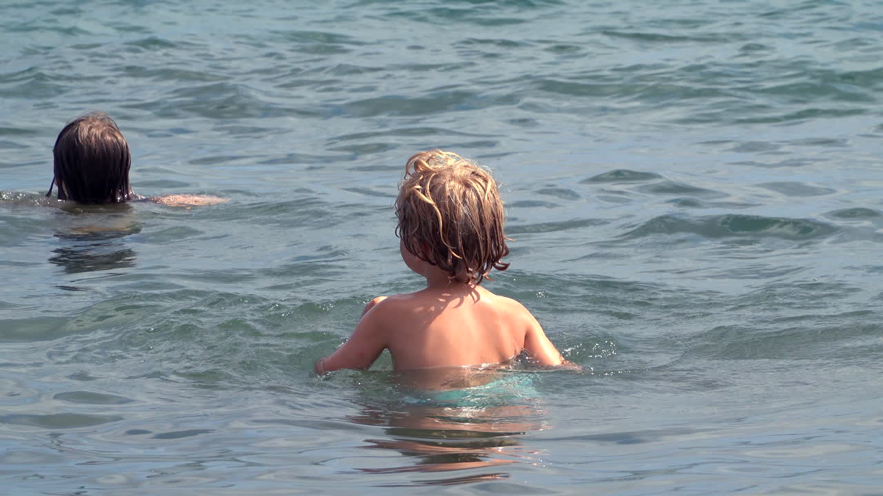 Children playing in the sea in Golfe Juan, France on a sunny day