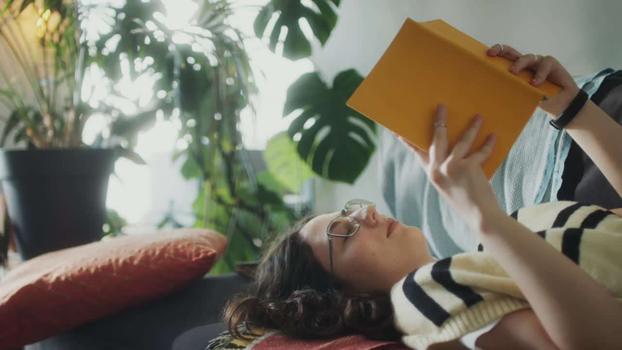 Girl Reading Book on Couch at Home