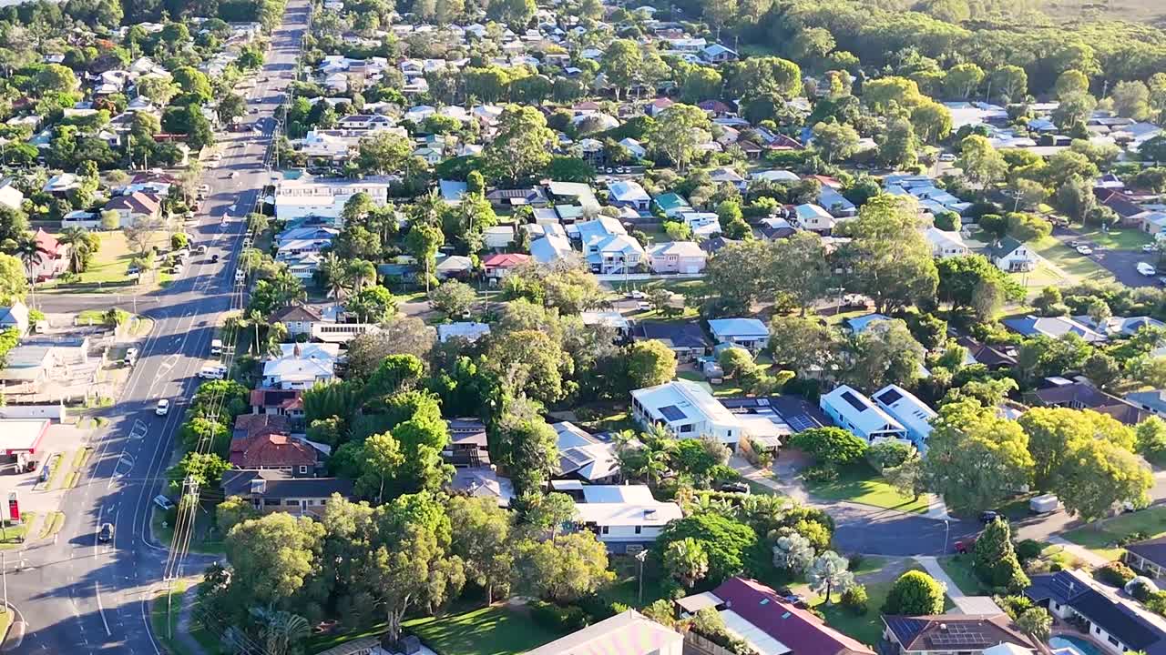 Aerial perspective of suburban streets lined with trees and residential houses, showcasing a peaceful neighborhood atmosphere.
