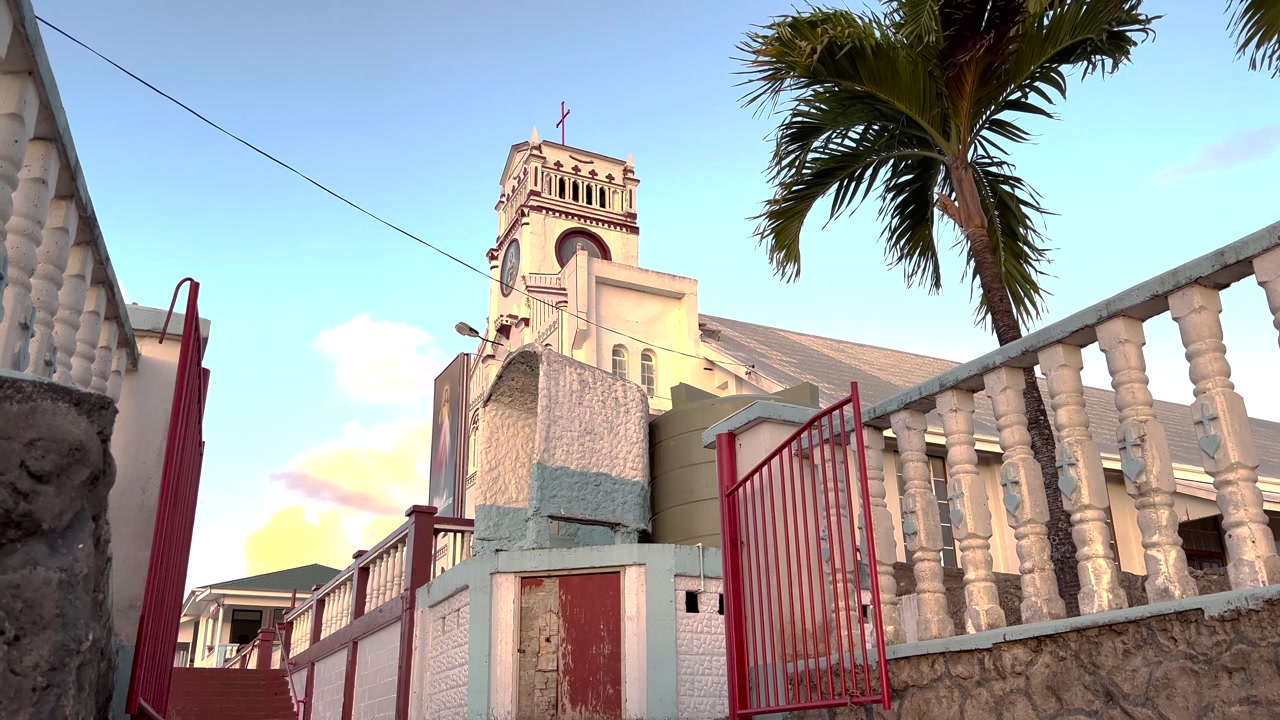 White cathedral tower with palm tree. Religious in Vava'u, Tonga, Pacific Islands. Christianity