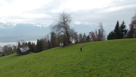 Filmische-Luftdrohne,-Schweizer-Alpen,-Landschaft,-Schöne-Frau,-Die-Im-Nebel-Tanzt,-Klänge-Der-Musikszene,-Thun,-Bern,-Interlocken,-Schweiz,-Berghang,-Langsam-Kreisende-Bewegung-Nach-Rechts