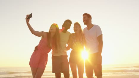 amigos adultos jóvenes tomando moscas en la playa al atardecer 4k