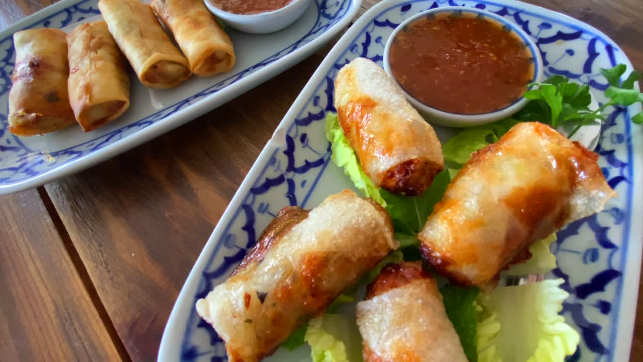 rollos de primavera tradicionales en lechuga con salsa de chile dulce en un restaurante tailandés, deliciosa comida asiática, tiro de 4k