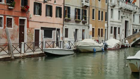 escena de un canal veneciano con edificios y barcos de colores