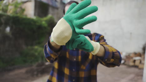 close up of male wearing gloves before starting working in his own gardening project